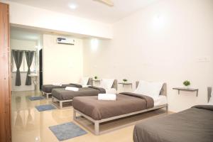 a room with three beds and a couch in it at Z Express Zen Elite in Pune