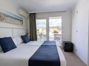 Llit o llits en una habitació de Hotel Medium Claramar