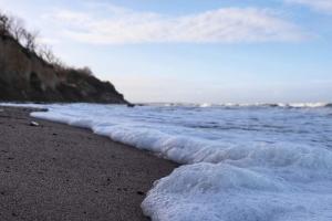 a beach with the ocean and the waves at Ferienwohnung und Ferienzimmer in Neubukow