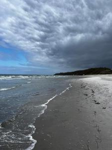 a beach with a cloudy sky and the ocean at Ferienwohnung und Ferienzimmer in Neubukow +28 photos
