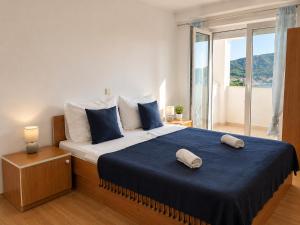 a bedroom with a large bed with two pillows on it at Pljesa Apartments -Meerblick mit Terrasse & Grill by rentyourhome24 in Supetarska Draga