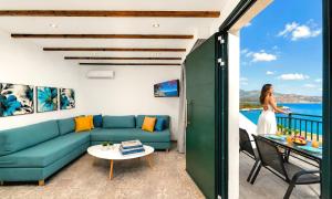 a woman standing in a living room with a blue couch at Istron Homes in Istro +28 photos