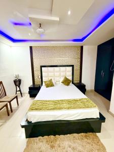 a bedroom with a large bed with purple lights at Hotel Umang in Sītāmarhi +10 photos