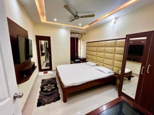 a bedroom with a bed and a flat screen tv at Hotel Umang in Sītāmarhi