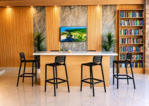 a bar in a library with four chairs around it at Paradise Resort Langkawi in Pantai Cenang