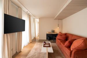 a living room with a couch and a flat screen tv at Hotel de Nell in Paris