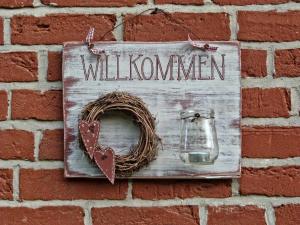 a sign hanging on a brick wall with a wreath at Beeck - FeWo mit Terrasse und Strandkorb in Oeversee