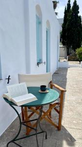 a table with a chair and a book and a cup of coffee at Captains Garden House in Katavatí +9 photos