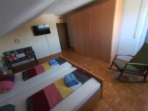 a living room with two beds and a chair at Ferienwohnung Zöller Villmar in Villmar