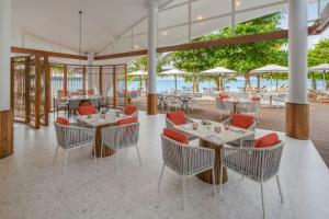 a restaurant with tables and chairs and a view of the ocean at The Westin Nirup Island Resort & Spa in Belakangpandang