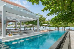 an infinity pool at the resort with chairs and umbrellas at The Westin Nirup Island Resort & Spa in Belakangpandang
