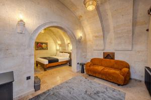 a bedroom with a bed and a couch in a room at Stone House Cave Hotel in Göreme