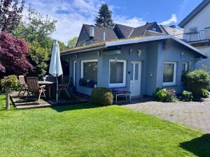 a blue house with a table and an umbrella at Tiny house with charm in Bremen