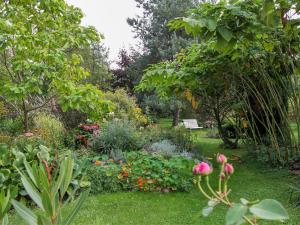 a garden with flowers and a bench in the background at Ferienwohnung Alte Dorfschule in Lüssow