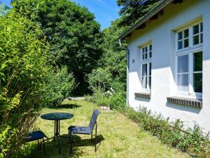 a table and chairs next to a house at Ferienwohnung Alte Dorfschule in Lüssow