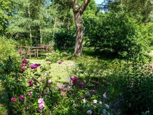 a garden with a wooden bench and flowers at Ferienwohnung Alte Dorfschule in Lüssow
