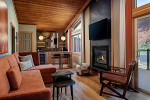 a living room with a couch and a fireplace at Red Cliffs Lodge Moab in Castle Valley