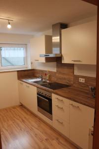 a kitchen with white cabinets and a sink and a window at Gästehaus Schwien in Rust