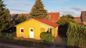 a small yellow house with a red roof at kleines Ferienhaus am Feldrand in Malchow