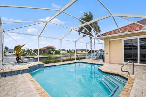 a swimming pool in front of a house at Sunsets At Tiki Terrace in Cape Coral