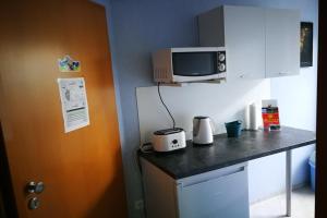 a kitchen with a counter top with a microwave at Gästezimmer Sieg in Rust