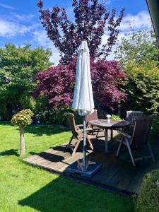 an umbrella and two chairs and a table on a deck at Tiny house with charm in Bremen