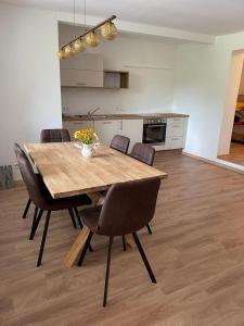 a dining room table with chairs and a kitchen at Ferienwohnung Seestern-Mondsee in Unterach am Attersee