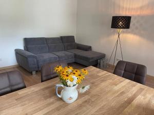a living room with a table with a vase of flowers at Ferienwohnung Seestern-Mondsee in Unterach am Attersee