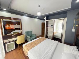 a bedroom with a bed and a desk and a television at Karakoçan Hotel Hanedan in Karakoçan