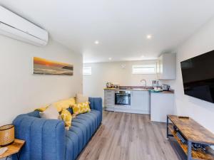 a living room with a blue couch and a kitchen at Kingsleys Lodge in Barnstaple