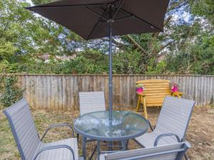 a glass table with chairs and an umbrella at Kingsleys Lodge in Barnstaple +8 photos