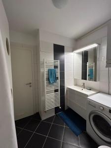 a bathroom with a sink and a washing machine at Apartmani Sime in Savar +102 photos