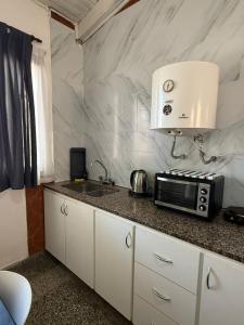 a kitchen with a sink and a microwave on a counter at Casa YRIGOYEN in Junín +13 photos