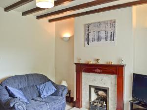 a living room with a couch and a fireplace at No 2 Flowery Bank in Malton