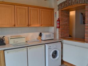 a kitchen with a washing machine and a microwave at No 2 Flowery Bank in Malton +4 photos