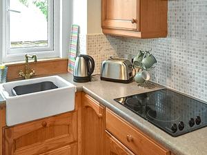 a kitchen with a sink and a counter top at Bothy Cottage - Uk51350 in Peebles