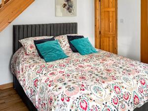 a bedroom with a bed with a colorful quilt at Bothy Cottage - Uk51350 in Peebles +2 photos