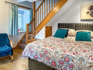 a bedroom with a bed and a staircase at Bothy Cottage - Uk51350 in Peebles
