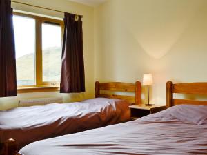 two beds in a room with a window at Blythswood in Glenfinnan