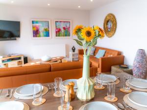 a table with a vase of sunflowers in a room at Sunset Beach - Uk42994 in Woolacombe