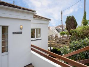 a white house with a balcony with a wooden fence at Whitestones in Saint Mawes