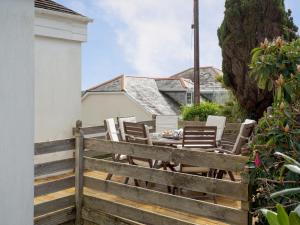 a patio with chairs and a table on a fence at Whitestones in Saint Mawes