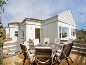 a patio with a table and chairs and a house at Whitestones in Saint Mawes