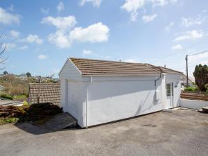 a white garage with a large door at Whitestones in Saint Mawes