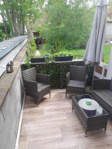 a patio with chairs and a table and an umbrella at Ferienwohnung Gertraude in Markranstädt