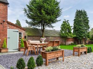 a patio with a table and chairs in a garden at Brynfields in Ashbourne