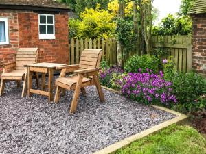 a garden with two chairs and a table and flowers at Brynfields in Ashbourne
