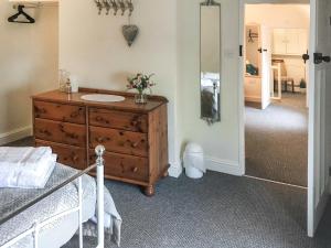 a bedroom with a bed and a dresser with a mirror at Brynfields in Ashbourne