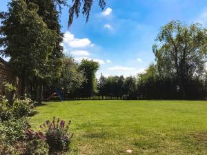 a large grassy yard with a fence and a playground at Brynfields in Ashbourne