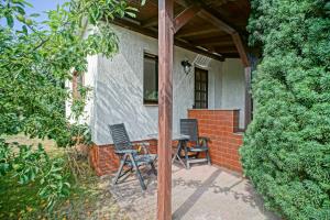 two chairs and a table on the porch of a house at Haff-Ostseeferienhausapartment Erdgeschoß in Mönkebude